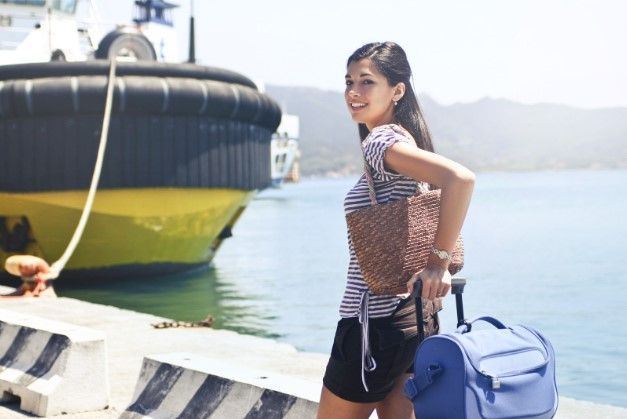 young woman boarding a cruise ship with luggage